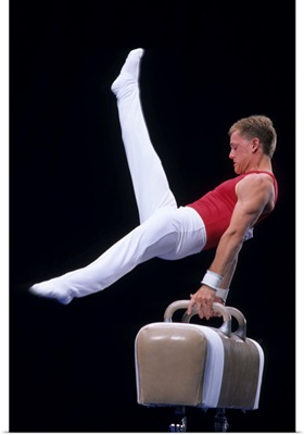 Male gymnast performing on the pommel horse