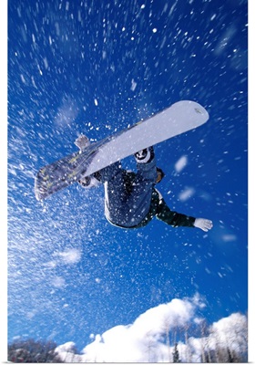 Male snowboarder flying through the air