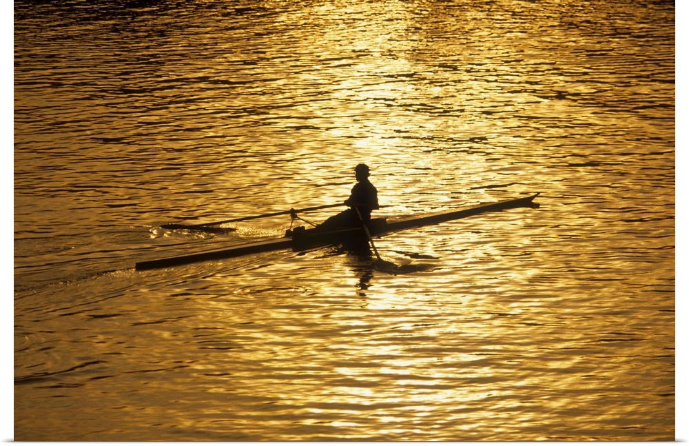 Rower silhouetted on a lake