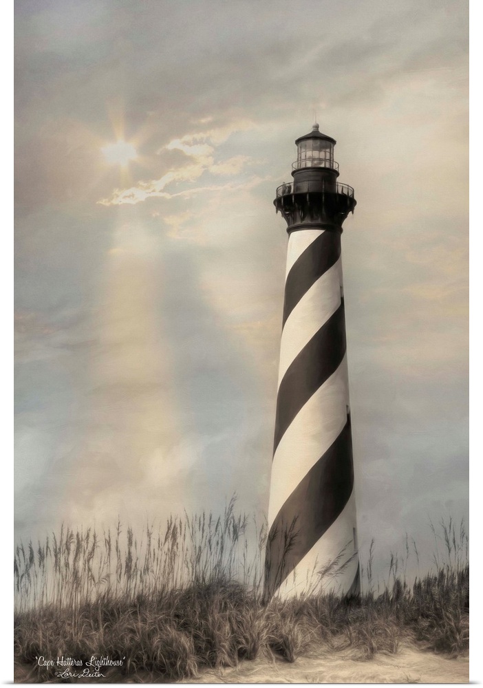 Black and white striped Cape Hatteras lighthouse on the Outer Banks with the sun shining through the overcast sky.