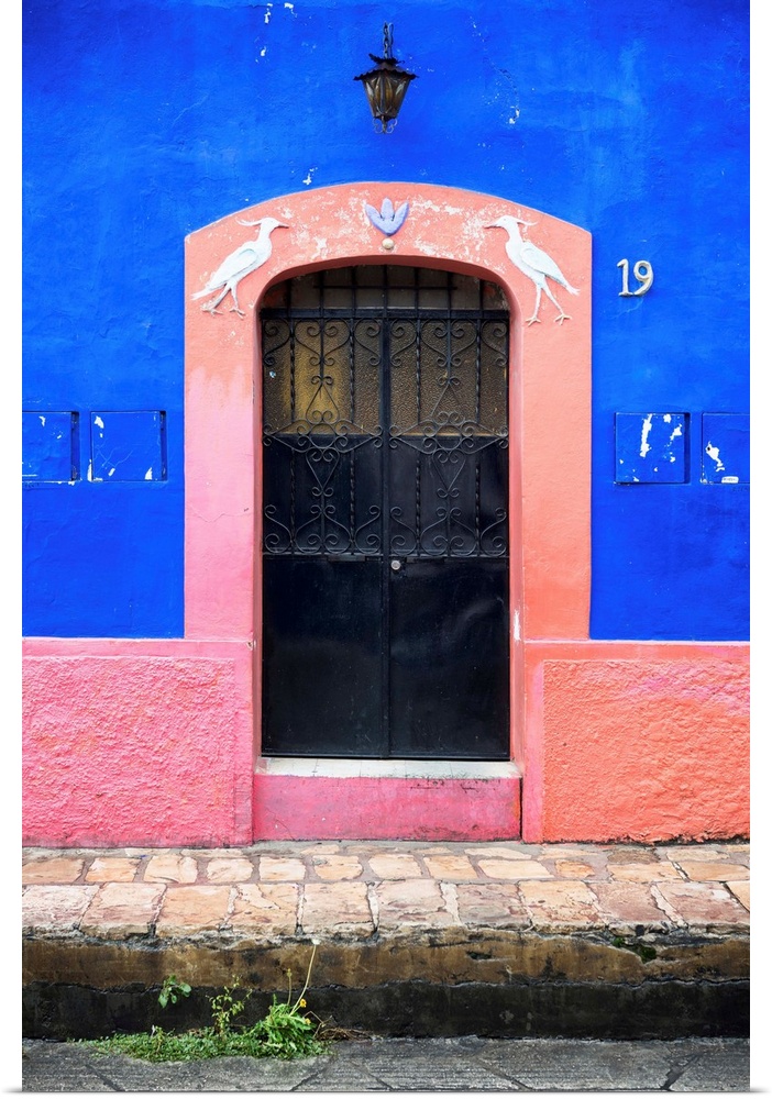 Photograph of the blue and pink exterior to a building highlighting the doorway. From the Viva Mexico Collection.