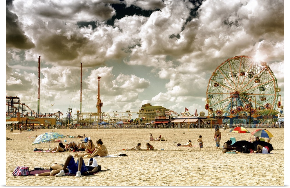 Photo of dramatic clouds over the sandy beach of Coney Island with carnival rides in the background.