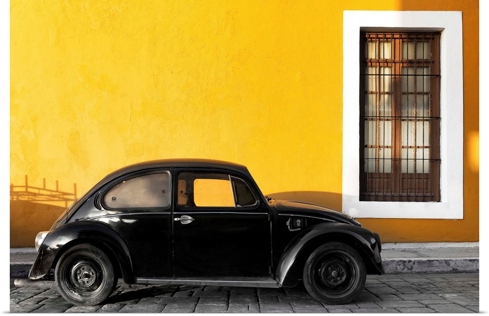 Photograph of a black Volkswagen Beetle parked on the street in front of a gold exterior wall. From the Viva Mexico Collec...