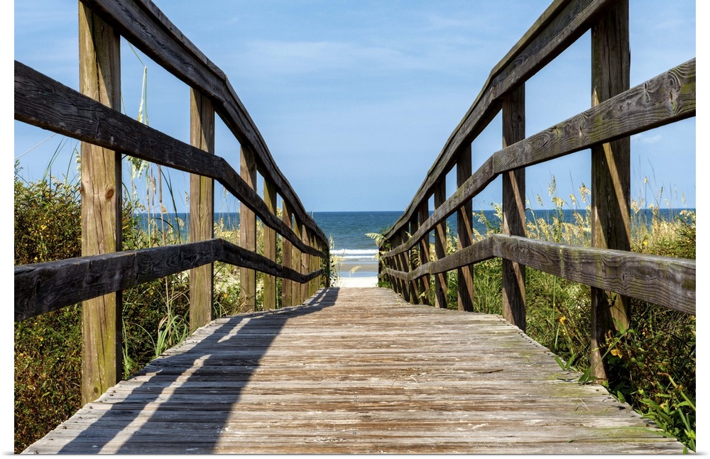 Wooden boardwalk leading to the sandy beach on the coast.