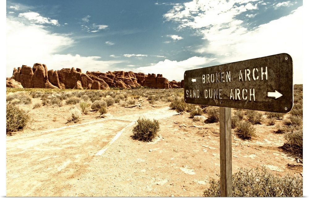 Signpost pointing towards Arches in opposite directions in the desert.