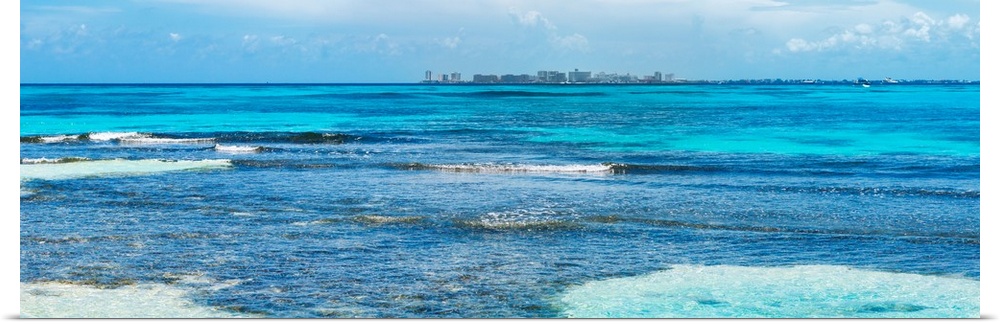 Panoramic photograph of the clear blue Caribbean ocean with the Cancun skyline in the background. From the Viva Mexico Pan...