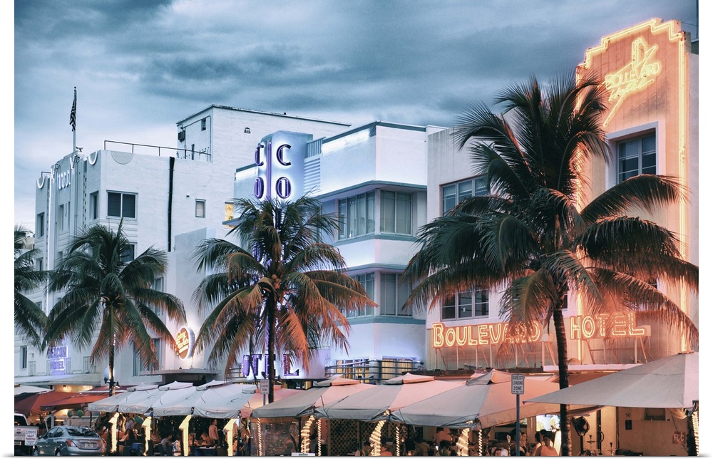 The buildings on Ocean Drive in Miami framed by palm trees and lit with neon lights.