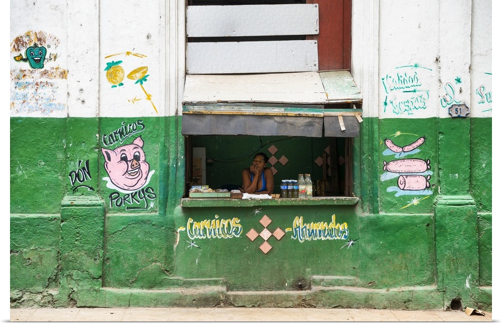 Photograph of a "hole in the wall" meat stop with a woman working the counter in Havana, Cuba.