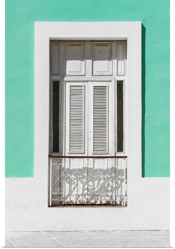 Photograph of a coral green and white facade with a window in Havana.