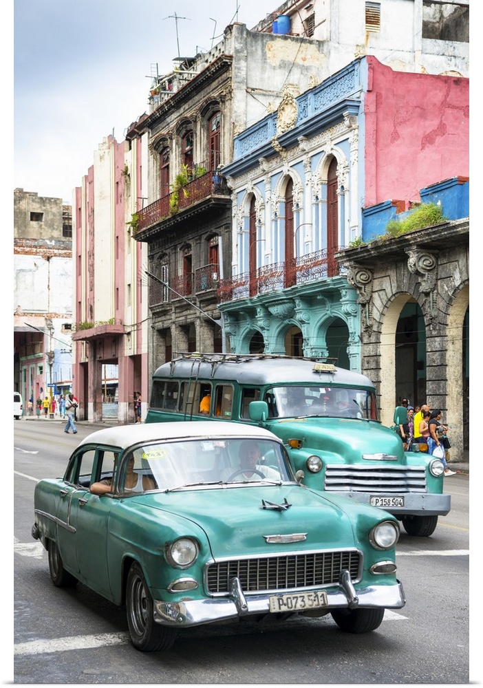 Photograph of two green vintage Chevrolets in a Havana street scene.