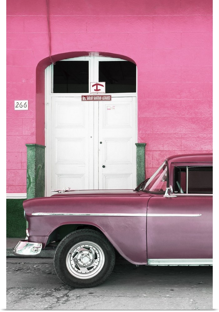 Vintage pink car parked in front of a pink facade with a white door.