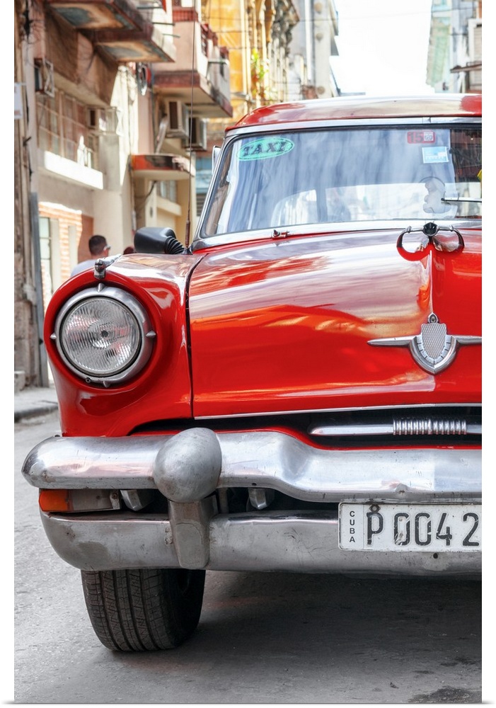 Photograph of the front of a bright red taxi cab in Havana.