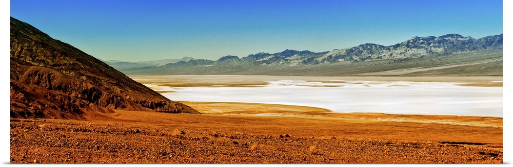 Photo of the Death Valley desert landscape, a flat plain bordered by low mountains.