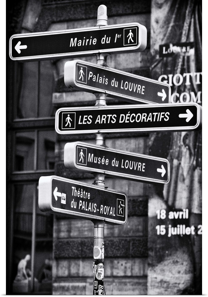 Black and white photograph of a signpost with several signs pointing towards different places of interest in Paris.