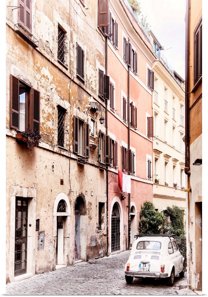 It's an old white Fiat 500 parked in a beautiful old cobbled street in the center of Rome, Italy.