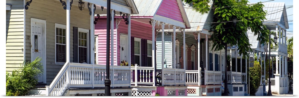 A row of classic houses in Key West, with one house painted bright pink.