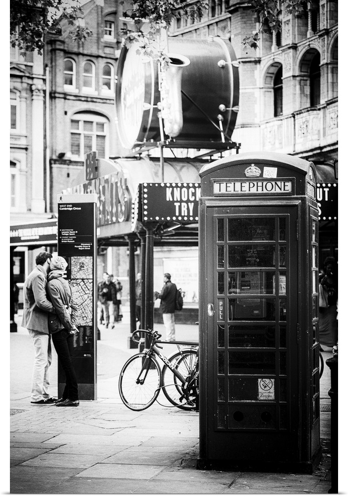 A couple in love being passionate beside an iconic London telephone booth.