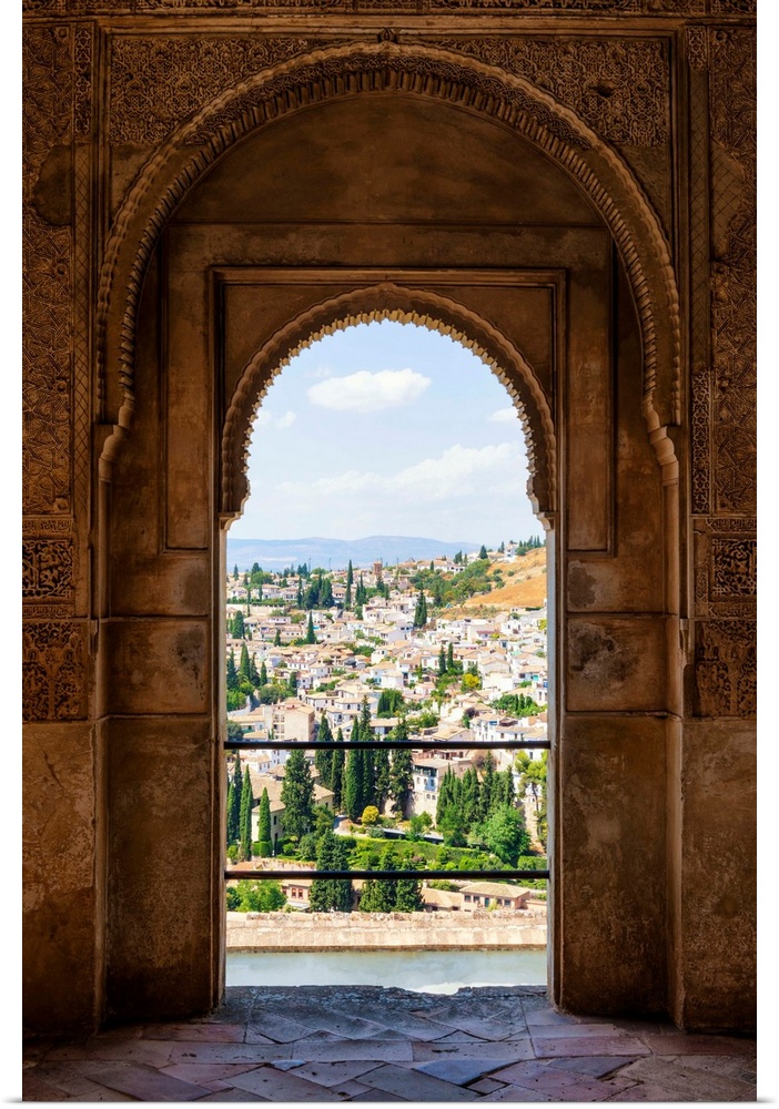 It's a view of the city of Granada by the ancient arches of the Alhambra, Spain.