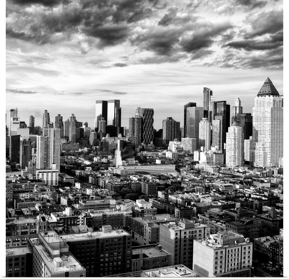 A black and white photo of the New York City skyline under dramatic clouds.