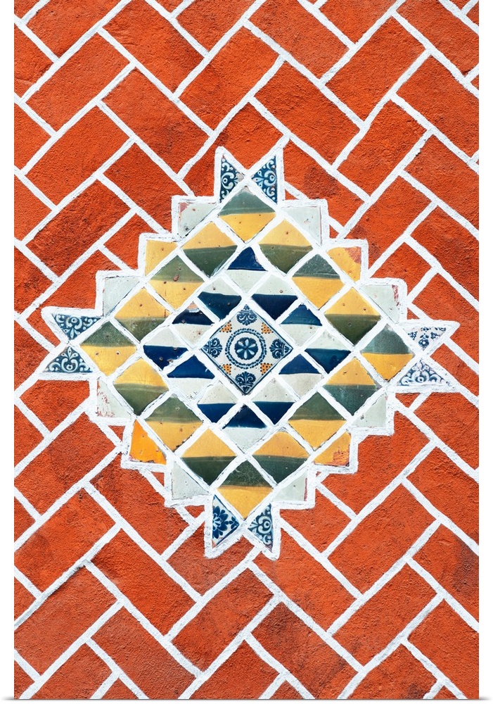 Decorative photograph of talavera tile creating a mosaic pattern surrounded by brick. From the Viva Mexico Collection.