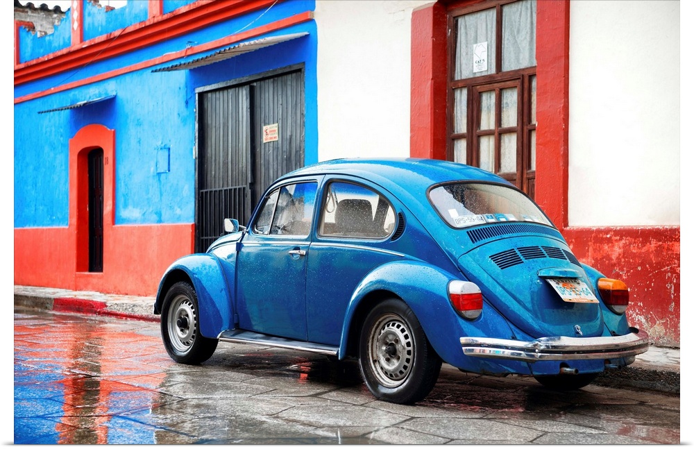 Photograph of a classic blue Volkswagen Beetle parked in front of a blue and red building. From the Viva Mexico Collection.