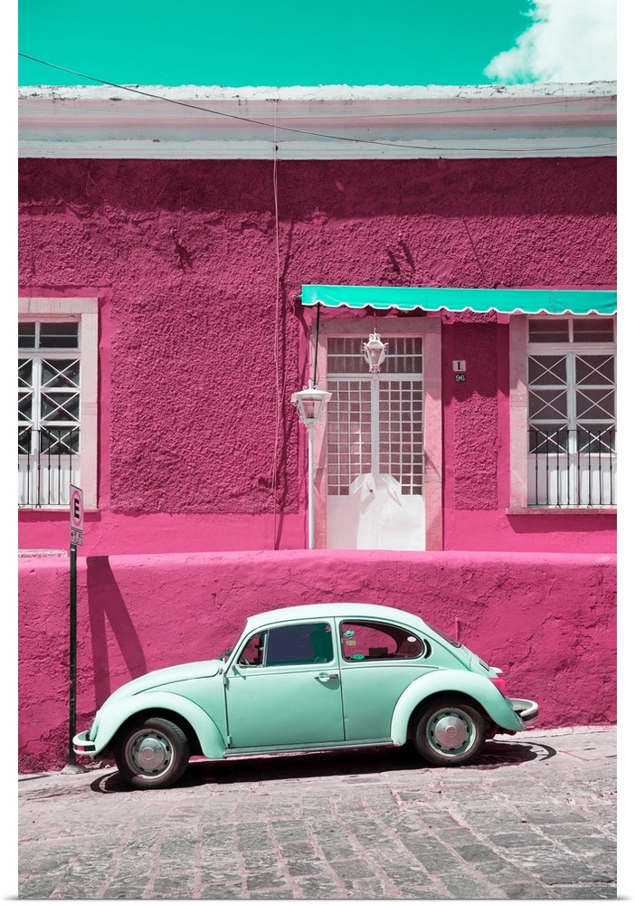Photograph of a classic Volkswagen Beetle in front of a pink and teal building. From the Viva Mexico Collection.