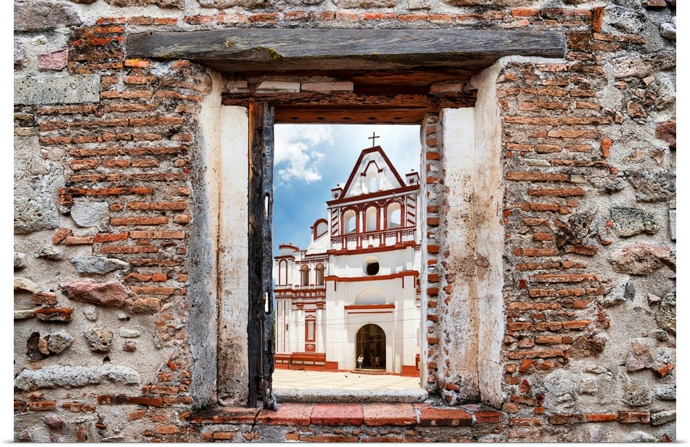 View of a white and red church in Mexico framed through a stony, brick window. From the Viva Mexico Window View.