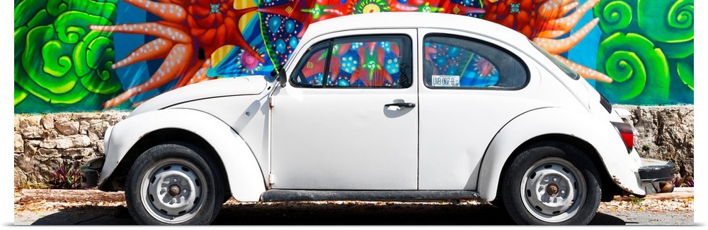 Panoramic photograph of a classic white Volkswagen Beetle parked in front of a colorful wall full of graffiti in Cancun, M...