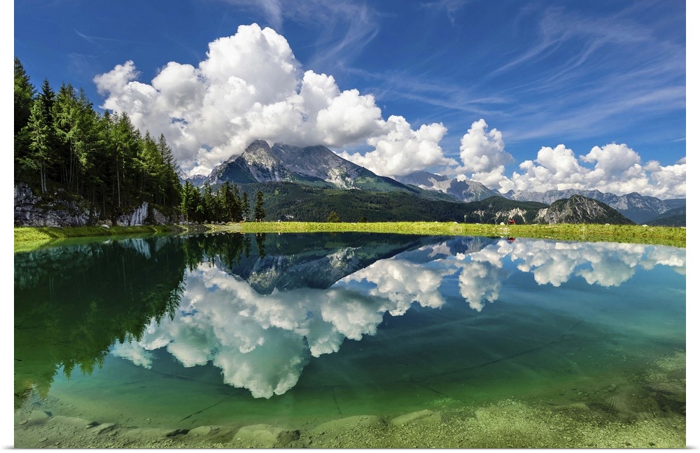 A clear lake in Berchtesgaden, Germany, reflecting the clouds and mountains.