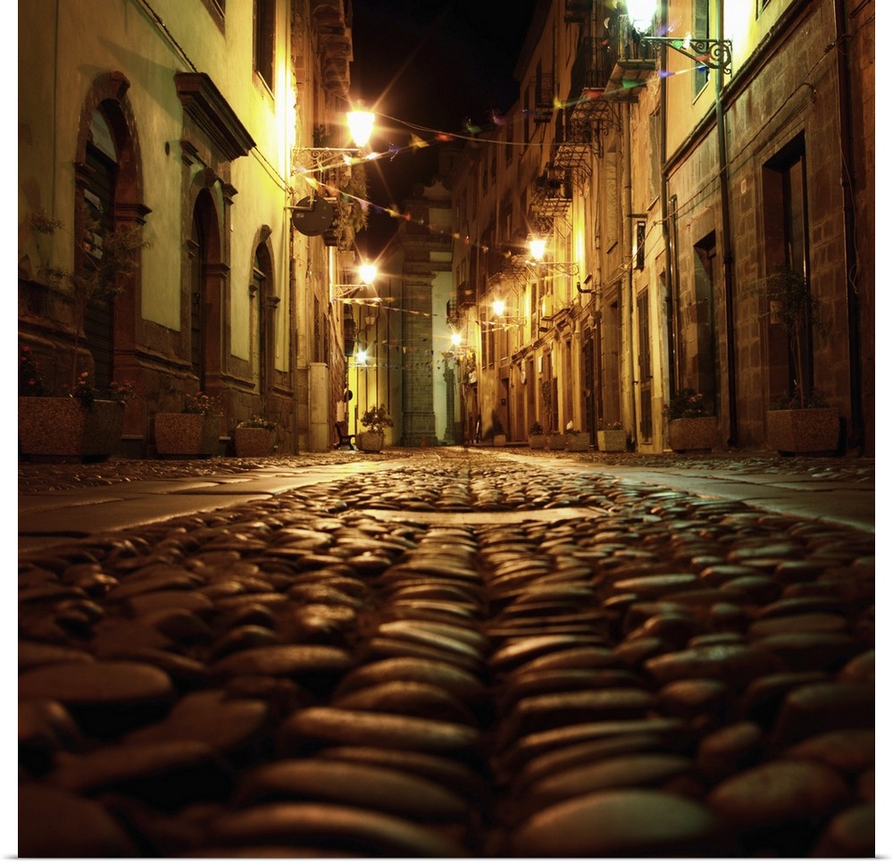 Cobblestone road in the city of Bosa, Italy, at night.