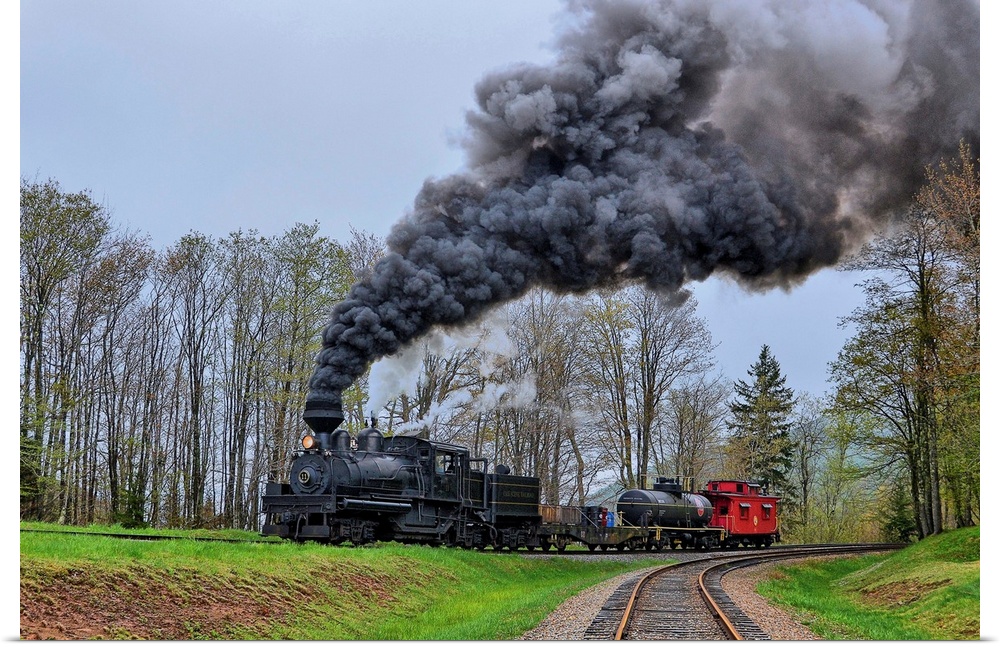 A locomotive with billowing black smoke climbs up a hill.