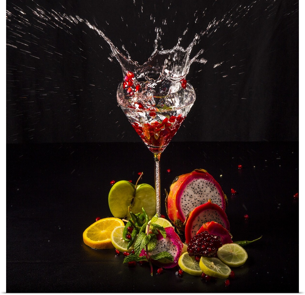 Fruit splashing into a glass of liquid.