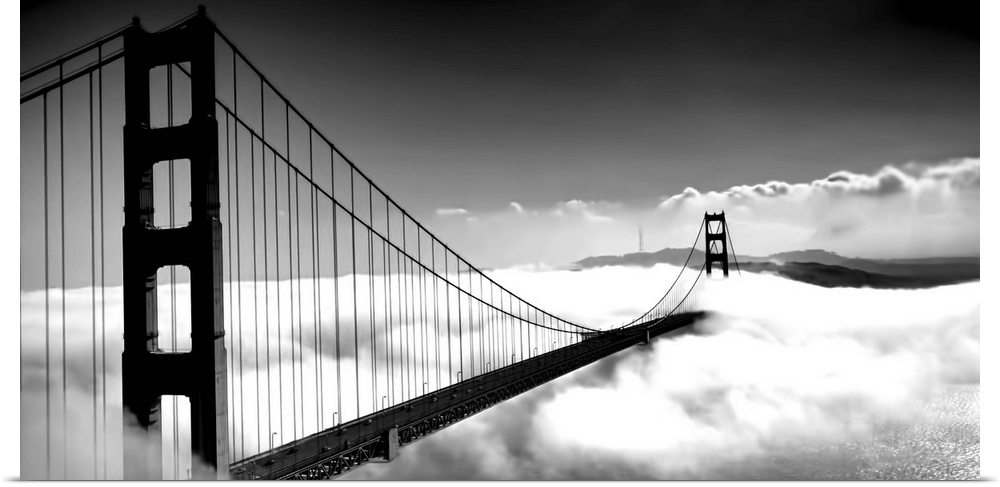 Black and white image of the Golden Gate Bridge in San Francisco rising above the clouds.