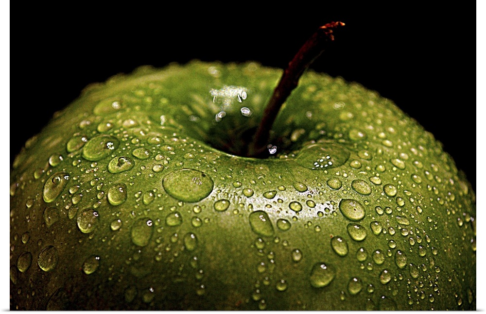 A bright green apple covered in water droplets.