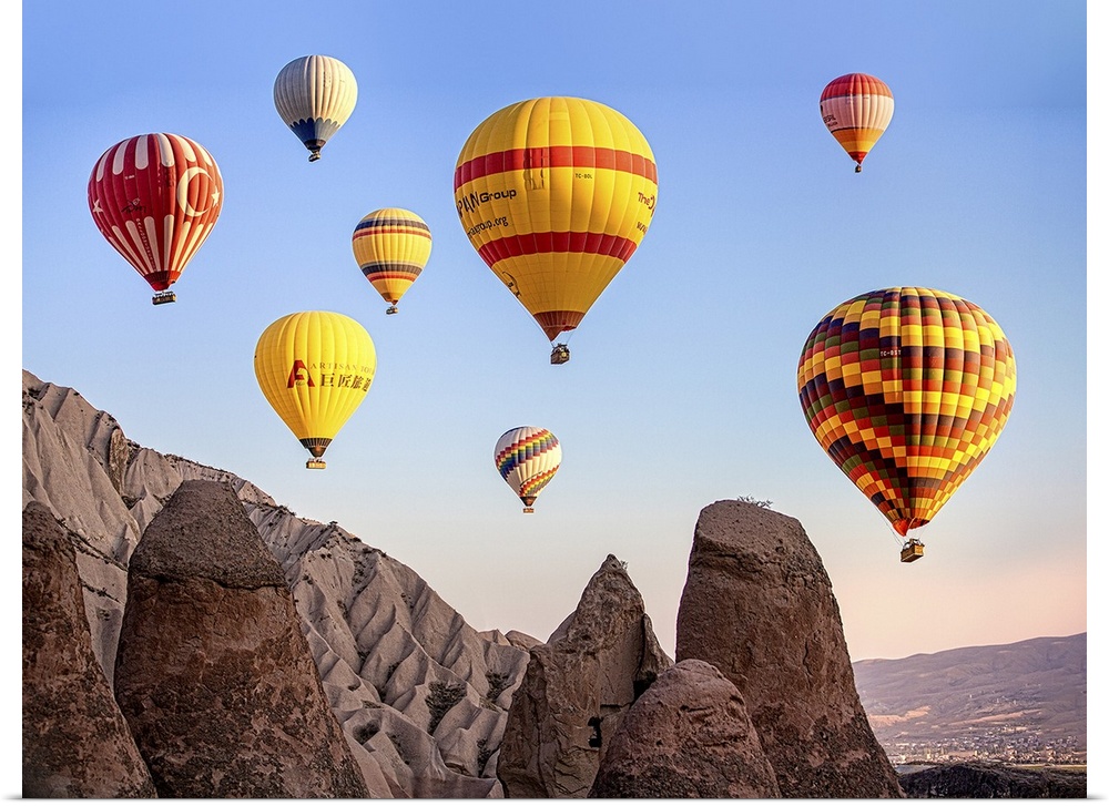 Large, colorful hot air balloons floating in the sky over Cappadocia, Turkey.