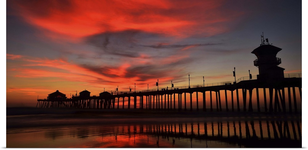 Huntington Beach Pier, California, at sunset, with bright red clouds above.