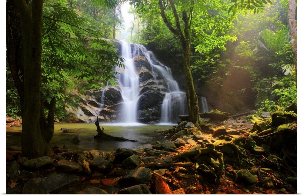 Photograph of a Malaysian forest with a view of a waterfall falling down over top of rocks.
