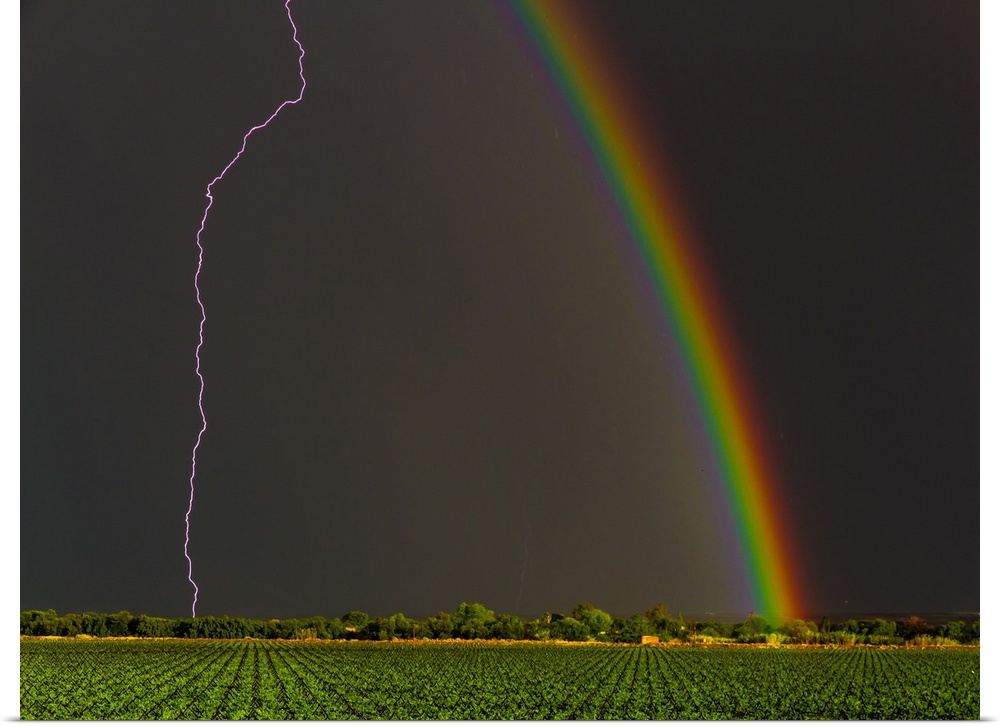 Lightning strike and a rainbow in the sky over Kanoneiland, South Africa.