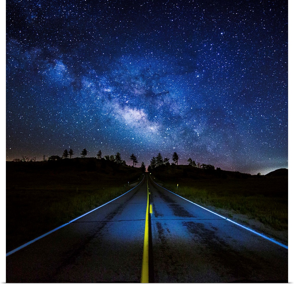 The Milky Way Galaxy visible in the night sky over a road.