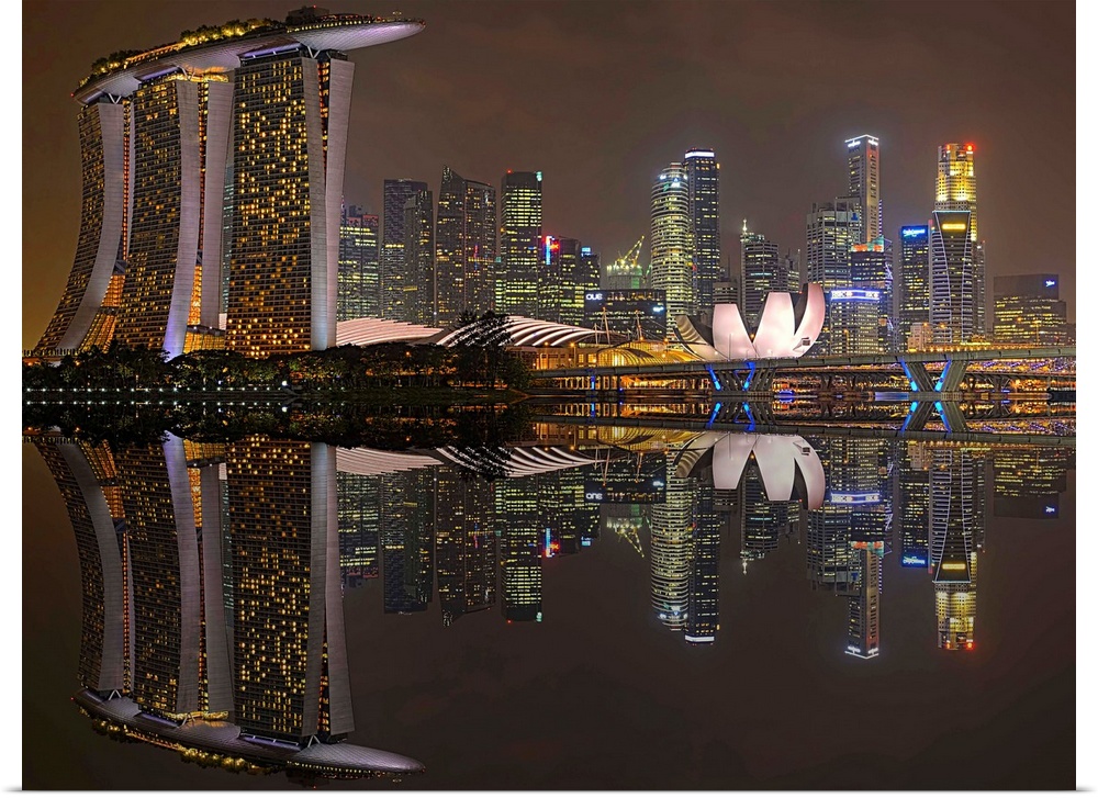 Skyscrapers in the city of Singapore at night, reflected in the waters of the marina.
