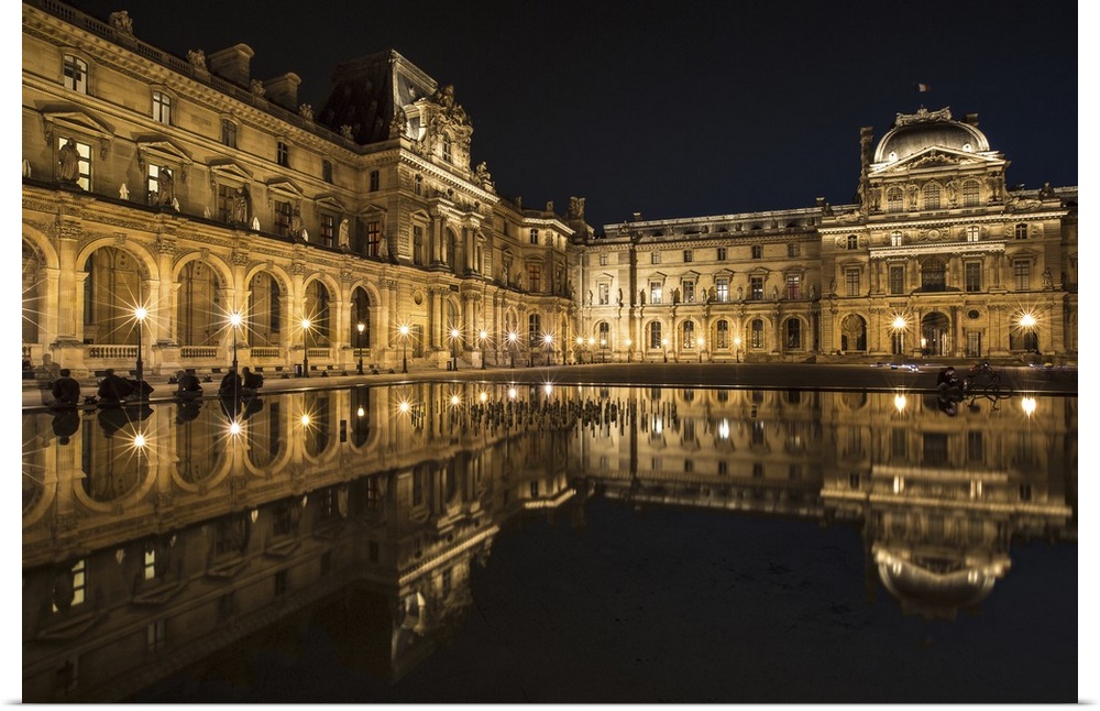 The Louvre Museum reflected in the waters of the fountain.