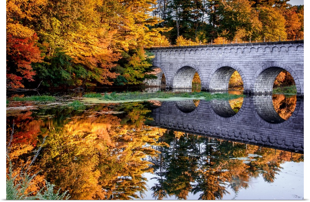 Stone arched bridge over a river in the fall, Massachusetts.