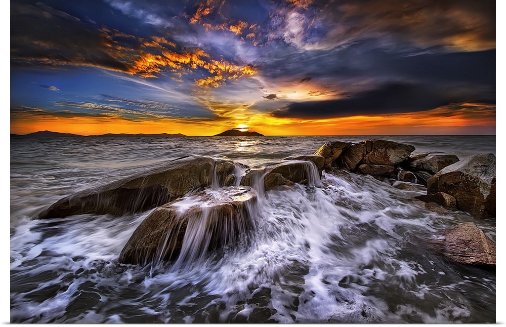 Photograph of a seascape at sunset with intense warm and cold clouds in the sky.