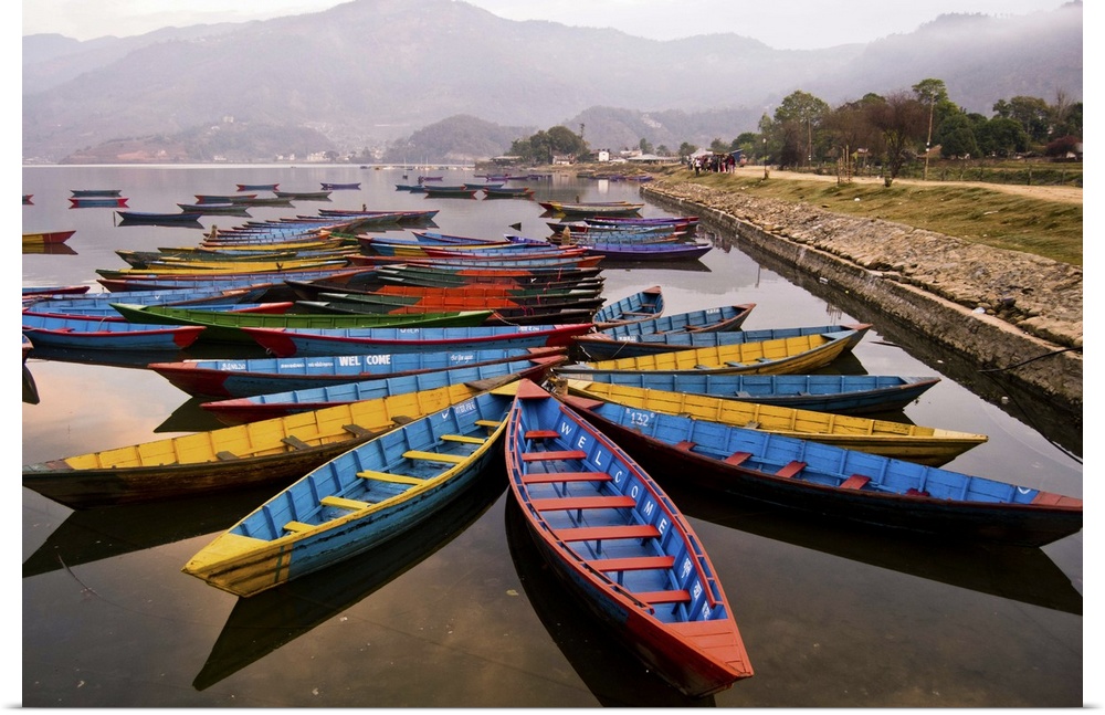 Long tail boats in star formations in a misty harbor in Nepal.