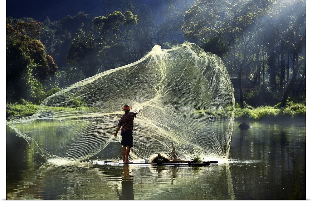A fisherman casting a large net into the air in the early morning light.