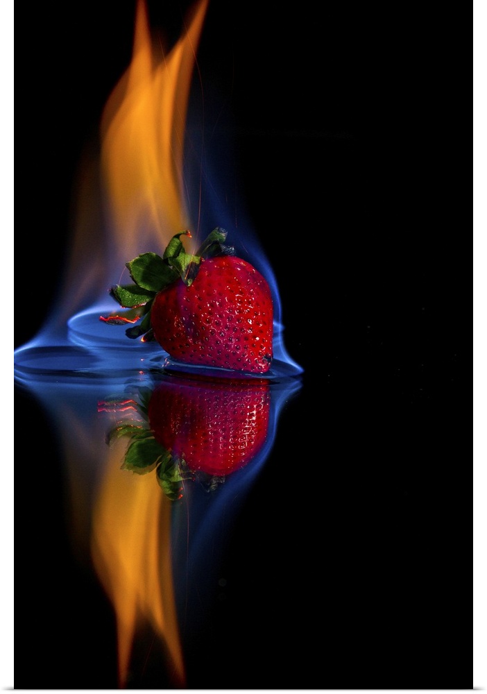Burning strawberry on a mirror with a black background.