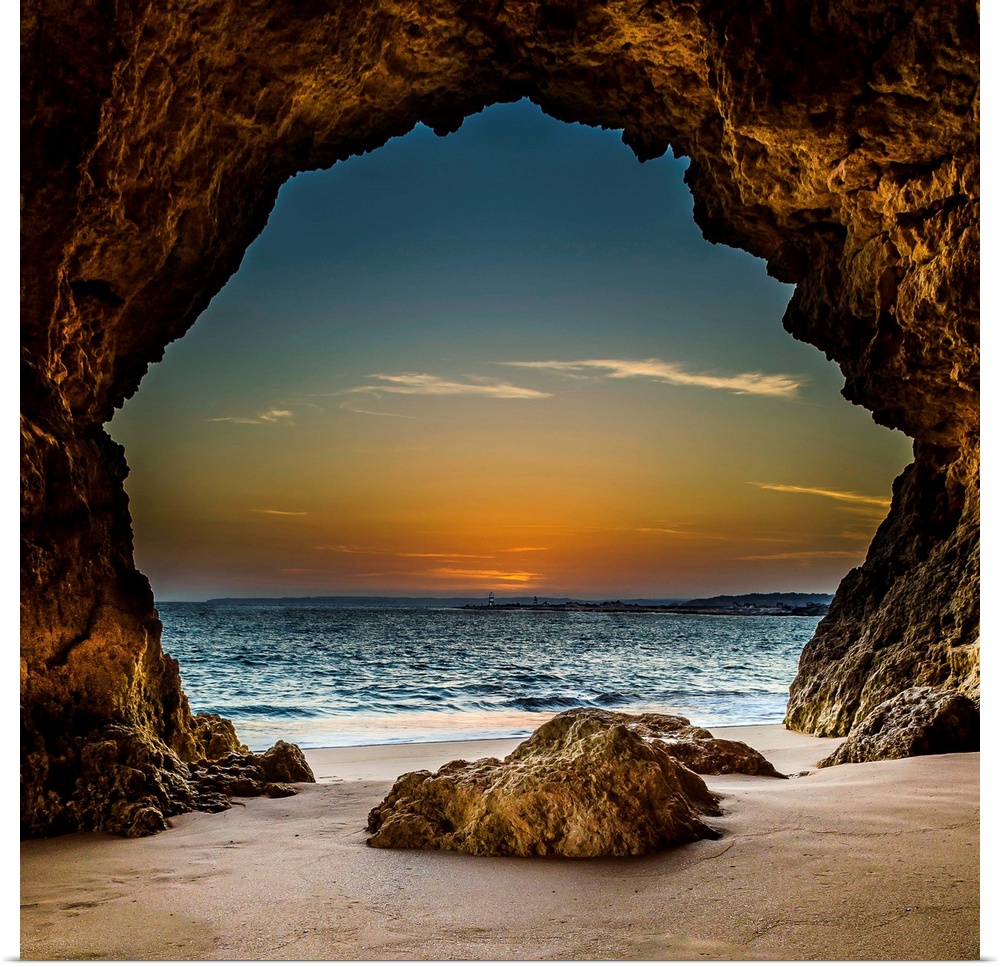 View from inside a cave on the beach, looking out at the sunset, Ferragudo, Portugal.
