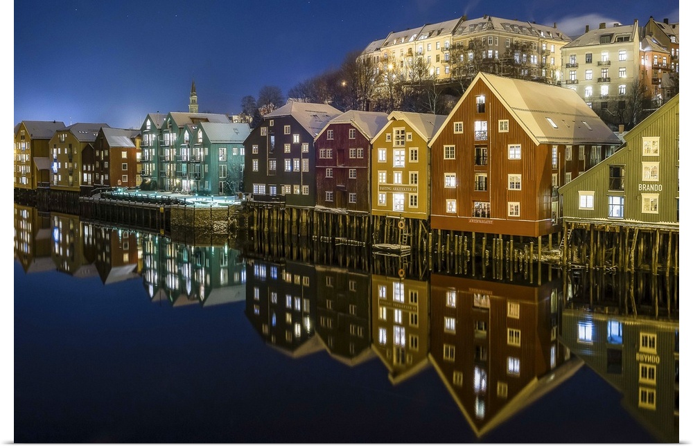 Photograph of a Norwegian houses reflecting in water below.