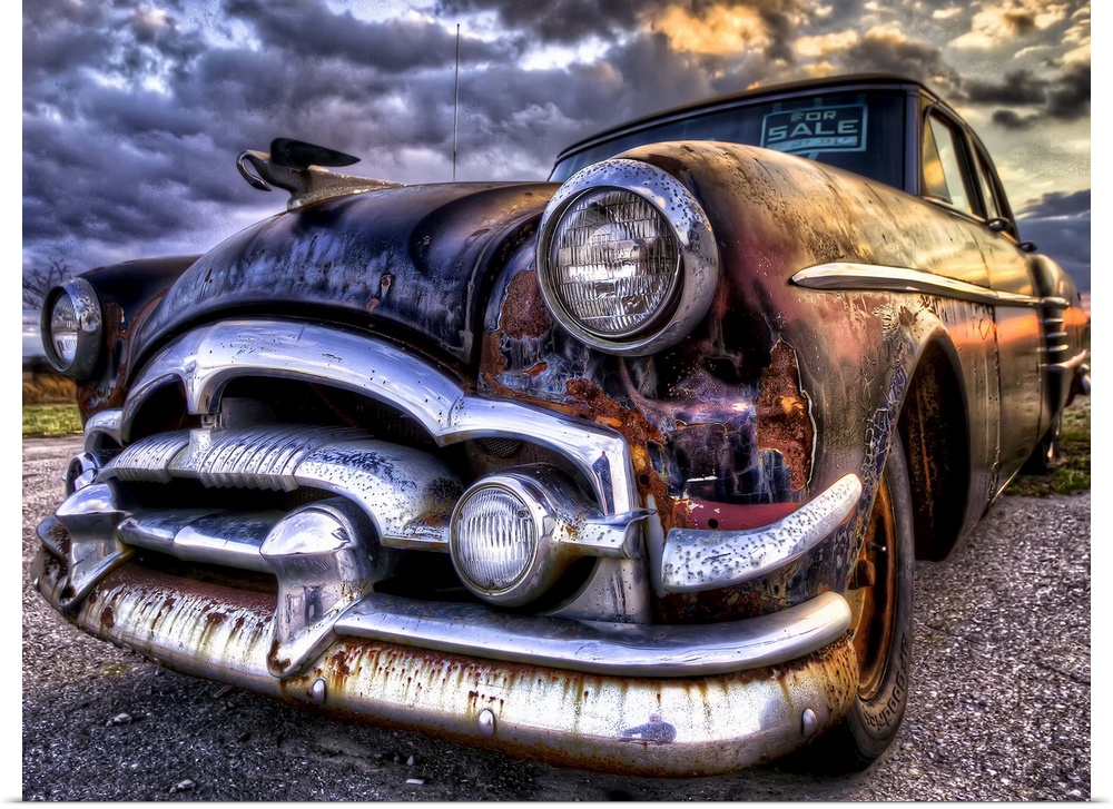 An old, rusted '54 Packard car with sunset light.