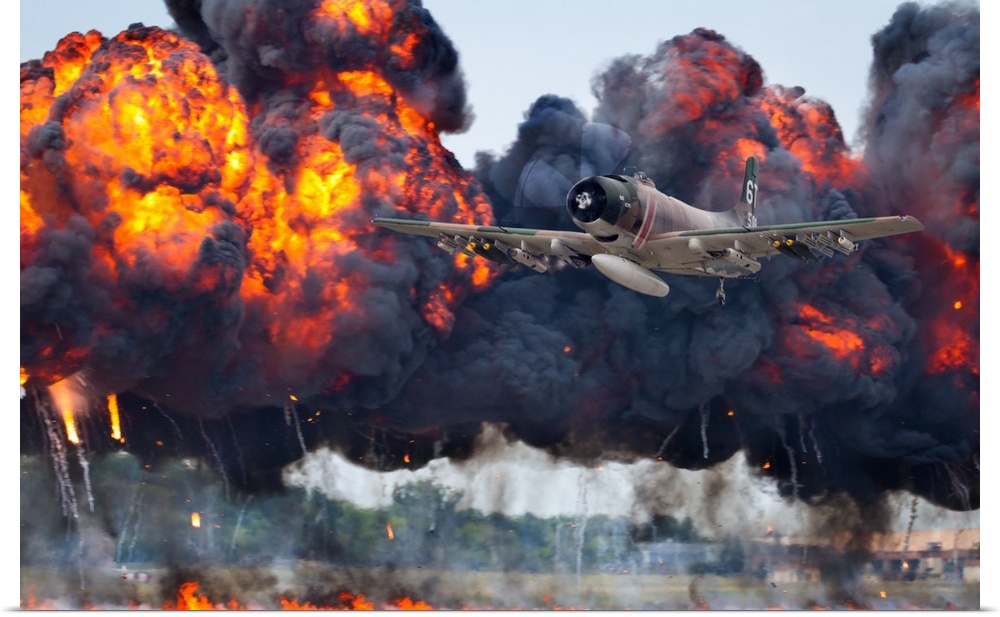 A military plane flies away from large fiery smoke clouds created by explosions.